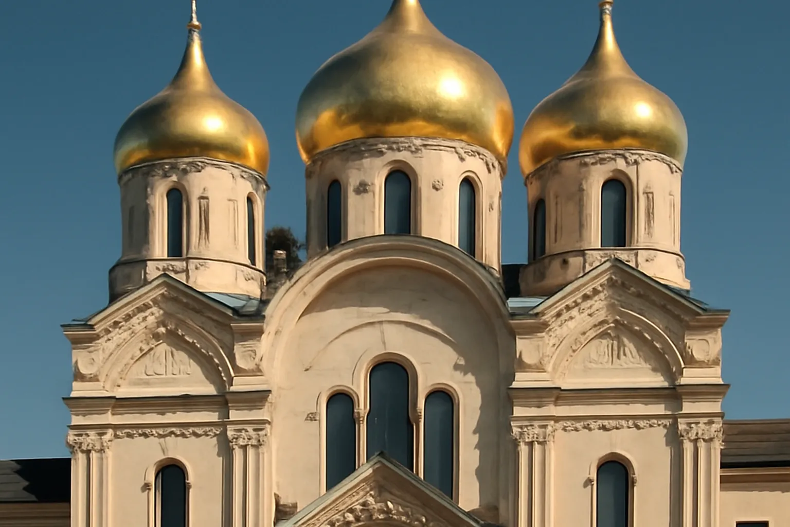 Vue extérieure d'une église orthodoxe russe en France avec coupoles dorées visibles, ciel bleu, style néo-russe